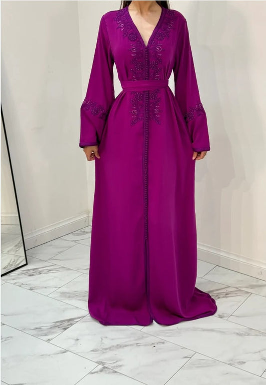 A purple full-length kaftan with embellishments on the chest area, worn by a model 
