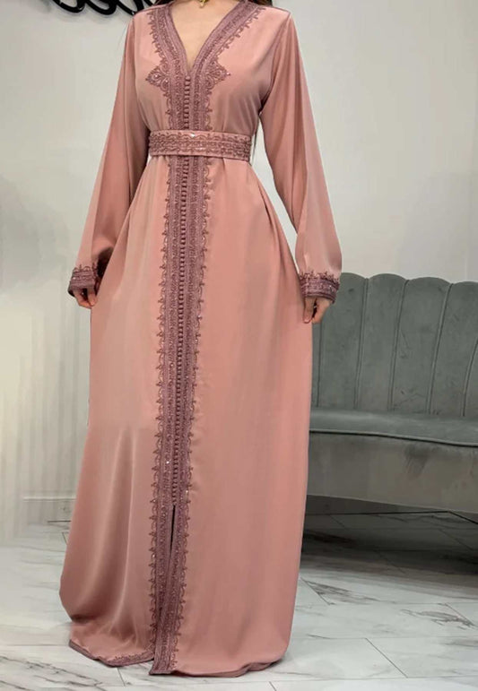 A long pink Kaftan dress with intricate detailing, displayed against a neutral background.