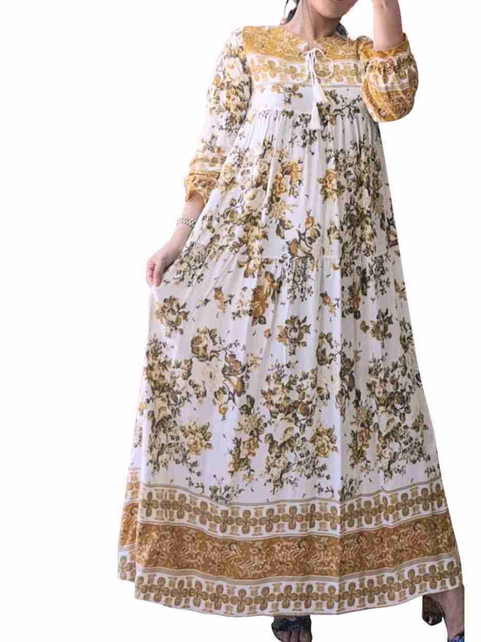 Long floral dress with yellow and brown patterns on a white background