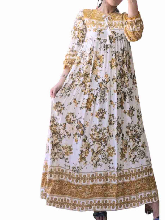 Long floral dress with yellow and brown patterns on a white background